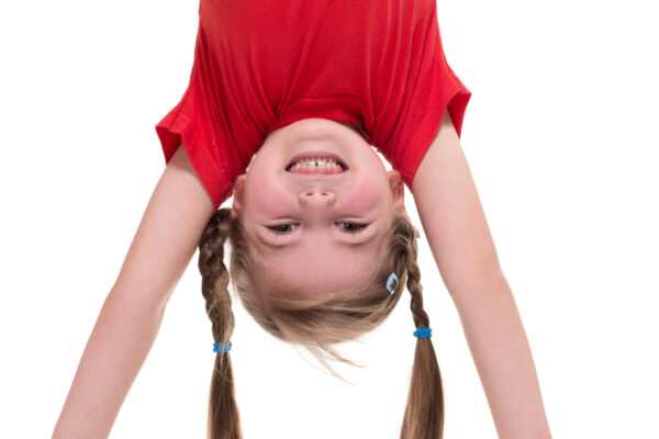 little girl standing on her hand isolated on white